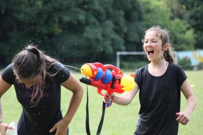 teenage girls having water fight at international english summer camp