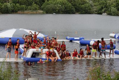children and teenagers at aqua park on summer camp trip in england