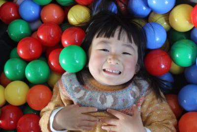 girl in ball pit smiling