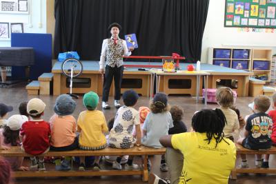 children and staff member watching magician show