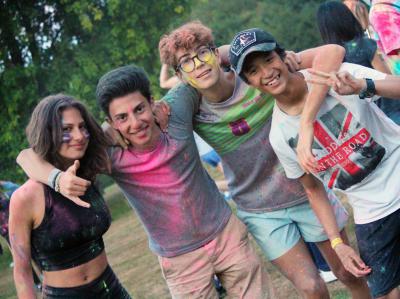 Four teenagers smiling covered in powder paint while at summer camp