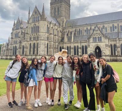 Group of children standing in front of Salisbury Cathedral while on a trip with XUK Camps