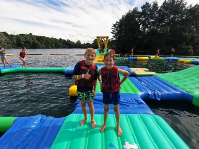 Two children smiling at an aqua park at summer camp