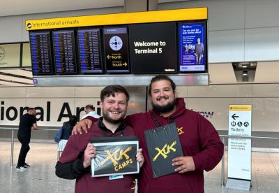 two XUK summer camp Staff members waiting to greet campers at the airport