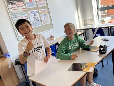 Two children laughing during their xuk English lesson