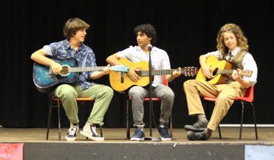 Three teenage boys playing guitar at XUK residential camp in the UK