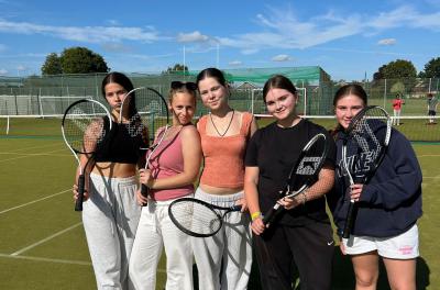 group of teenage girls ready to play tennis at a sports camp near me called XUK Summer Camp