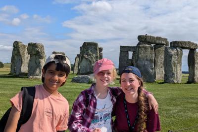 two children with XUK camps staff at Stonehenge