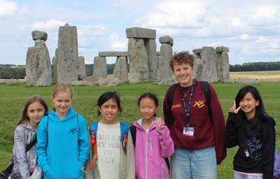 group of children and XUK Summer Camp staff member visiting Stonehenge