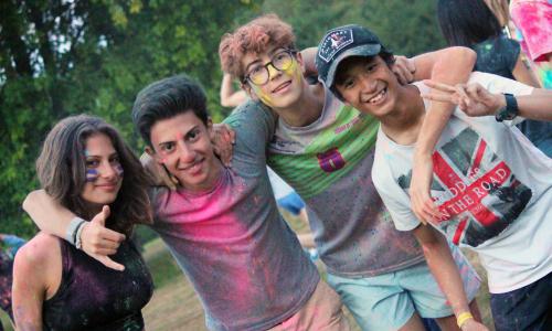 Four teenagers smiling covered in powder paint while at english summer school